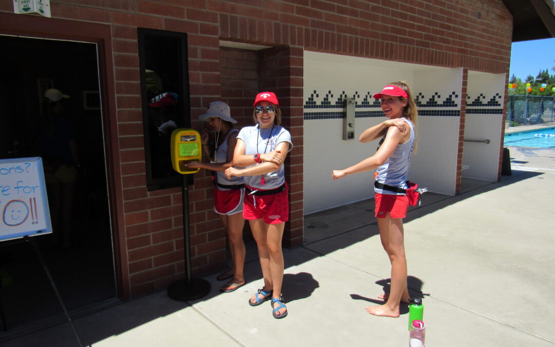 Light guards at an outdoor pool applying sunscreen from the BrightGuard automatic dispensers